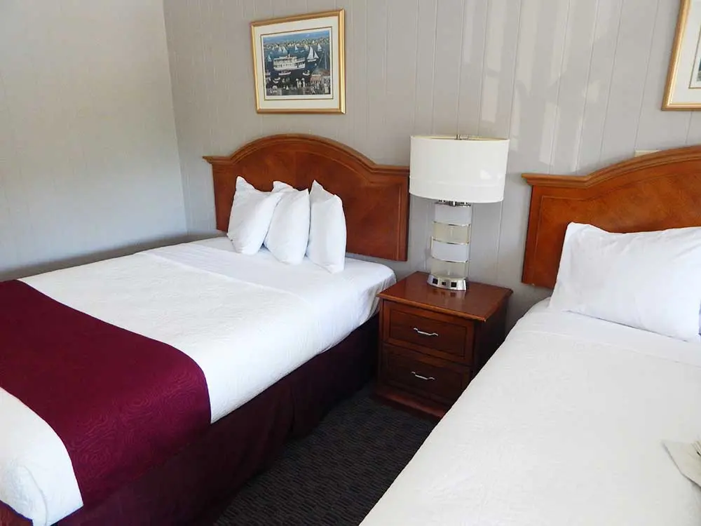 2 beds and nightstand in motel room