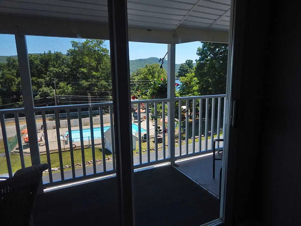view of pool from room with a balcony